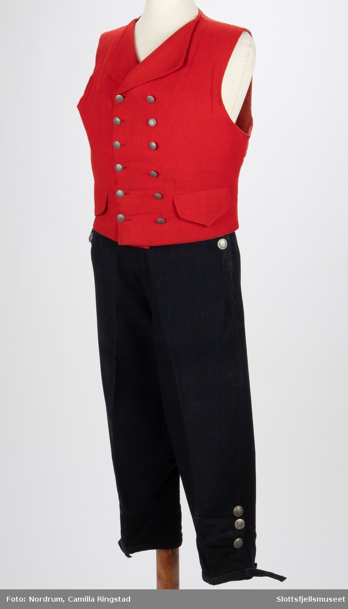 Mannsbunad fra Borre. Rød vest, mørkeblå bukse.