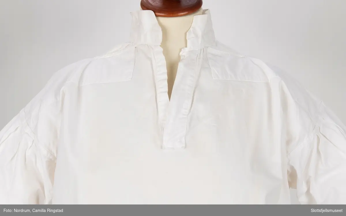 Hvit skjorte uten knapper.
