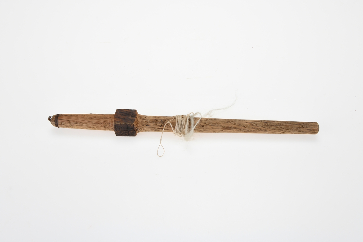 En håndtein skåret ut av tre med en jernkrok i enden. Under jernkroken er det surret tynn jerntråd to ganger rundt teinen. Nedenfor er teinen skåret ut slik at det er en firkant/kube på teinen. Opprinnelig har det hørt til et spinnehjul av kleberstein, men det ble borte ved innlevering til museet i 1929. 
Bruk: En tein eller håndtein er et redskap som brukes til å spinne tråd av ull eller lin. Redskapet består for det første av en tein av tre som har en jernkrok eller et innskåret hakk i enden. Teinen er trædd gjennom et hull i spinnehjulet og sitter fast i det. Spinningen foregår ved at tekstilfibre hentes fra håndrokken og festes til kroken. Når så teinen med svinghjulet settes i rotasjon, blir fibrene tvinnet sammen til tråd (https://snl.no/tein).