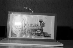 Fotografi av gammelt prærielokomotiv i ramme, som står på en