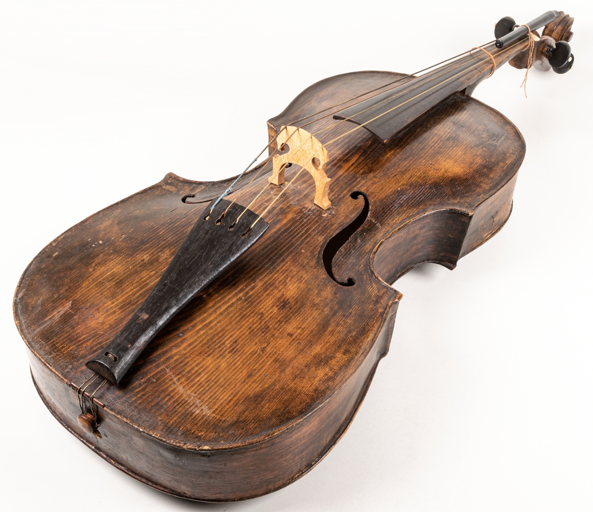 Cello, 1700-talet, brunsvart med 4 strängar, benknoppar på skruvarna för strängarnas spännande.
