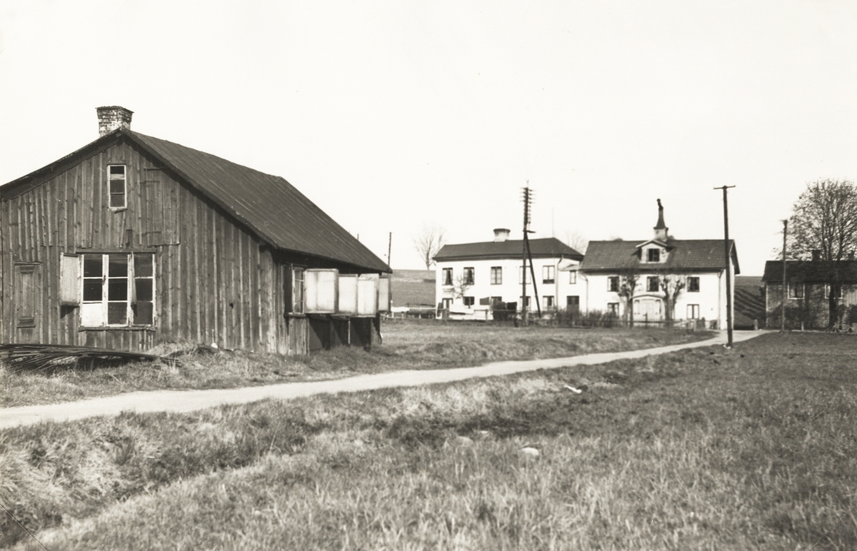 Fastigheter längs Gamla Norrvägen, Växjö, ca 1950. Till vänster Tenggrens smedja, som övertogs av Frans Erik Palm 1903. 
Till höger dåv. Johanssons damskrädderi.