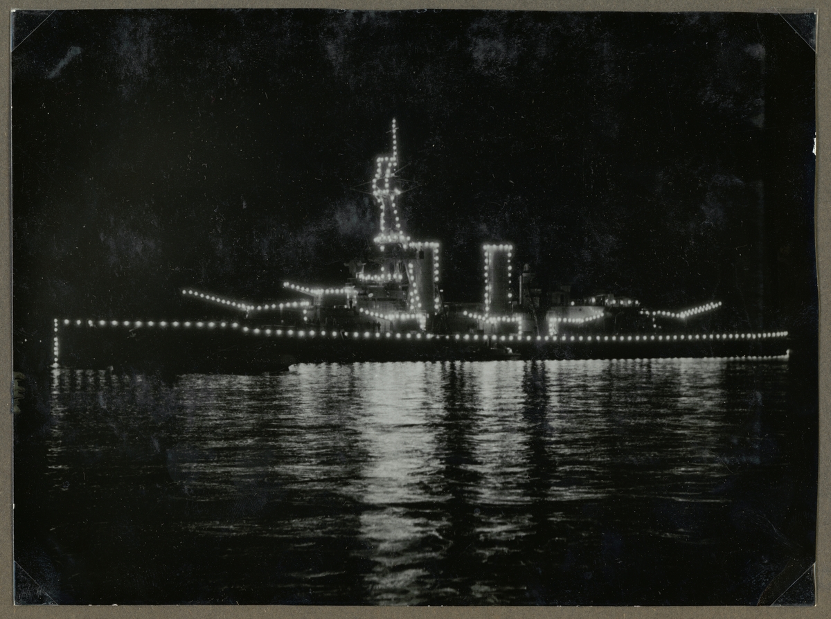 Bilden visar pansarskeppet Drottning Victoria på nattetid med full belysning.