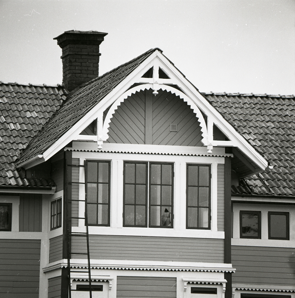 Utvändig utsmyckning på övervåning av ett boningshus i trä med liggande panel som fasad, 1980. Inglasad veranda på övervåningen.