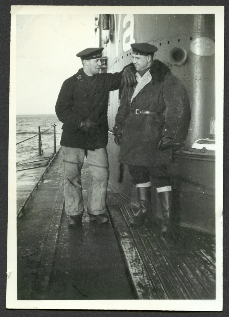 Bilden visar två sjömän i samtal med varandra på däck av ubåten Valen till sjöss.