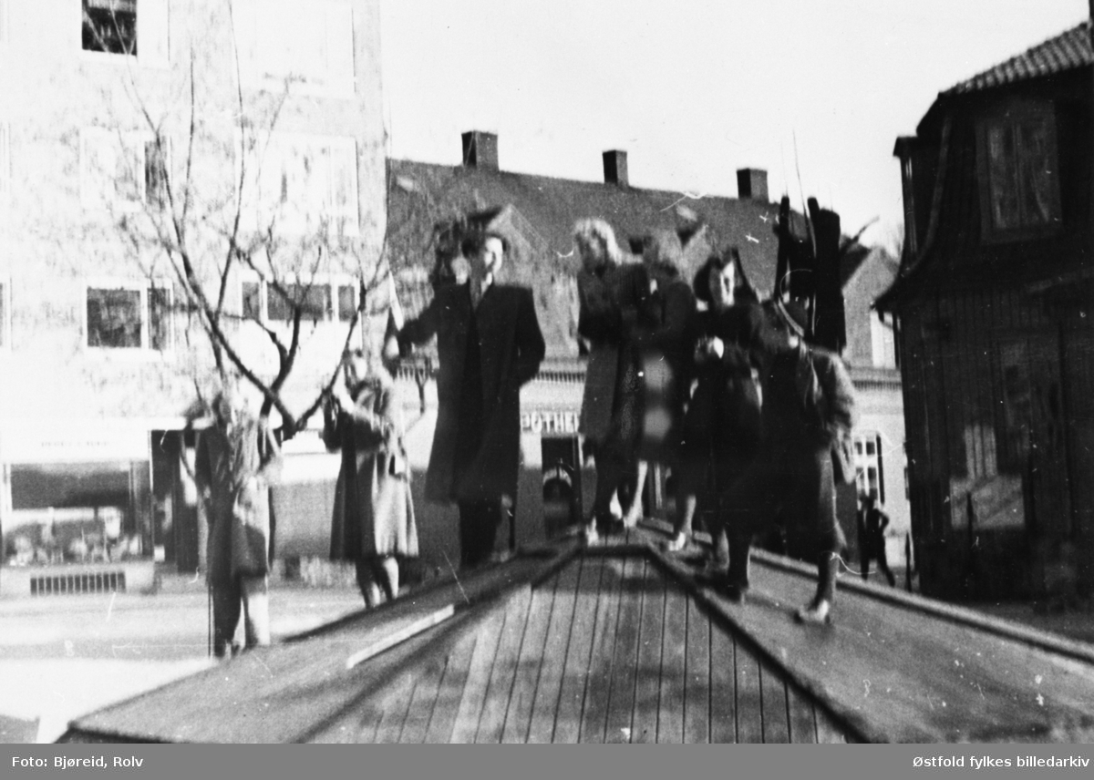 Da freden "brøt løs" i maidagene 1945. Mennesker på Sarpsborg torv, på taket av aviskiosk.