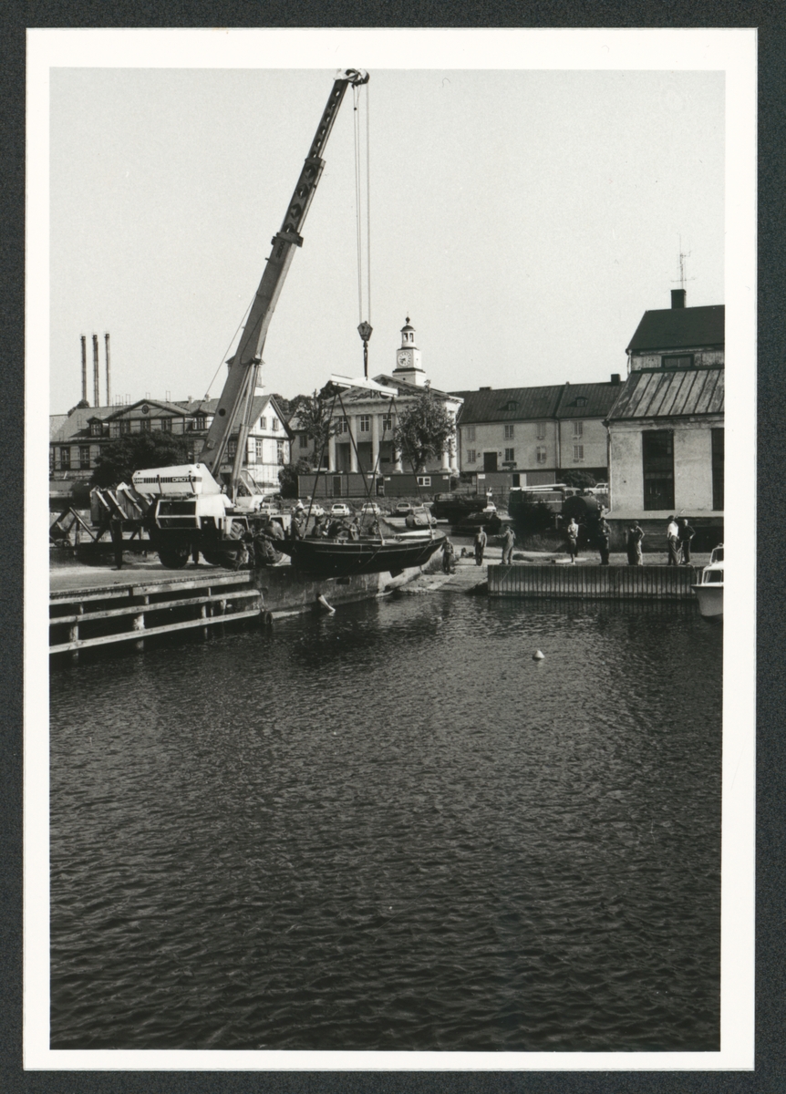 Serie som innehåller 9 motiv med olika moment under transport och lyft i vattnet av kungslupen nr 44 framför tackelkammaren på Karlskronas örlogsbas.