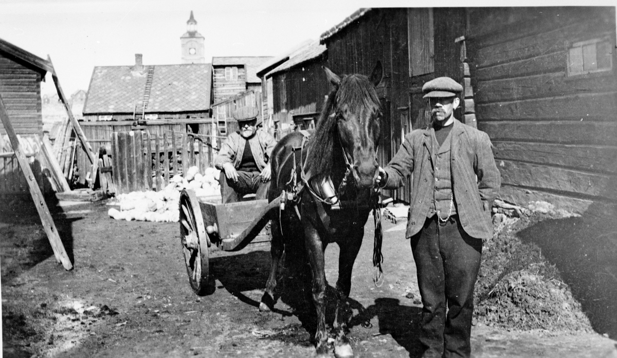 To menn med hest og vogn i gårdsrom