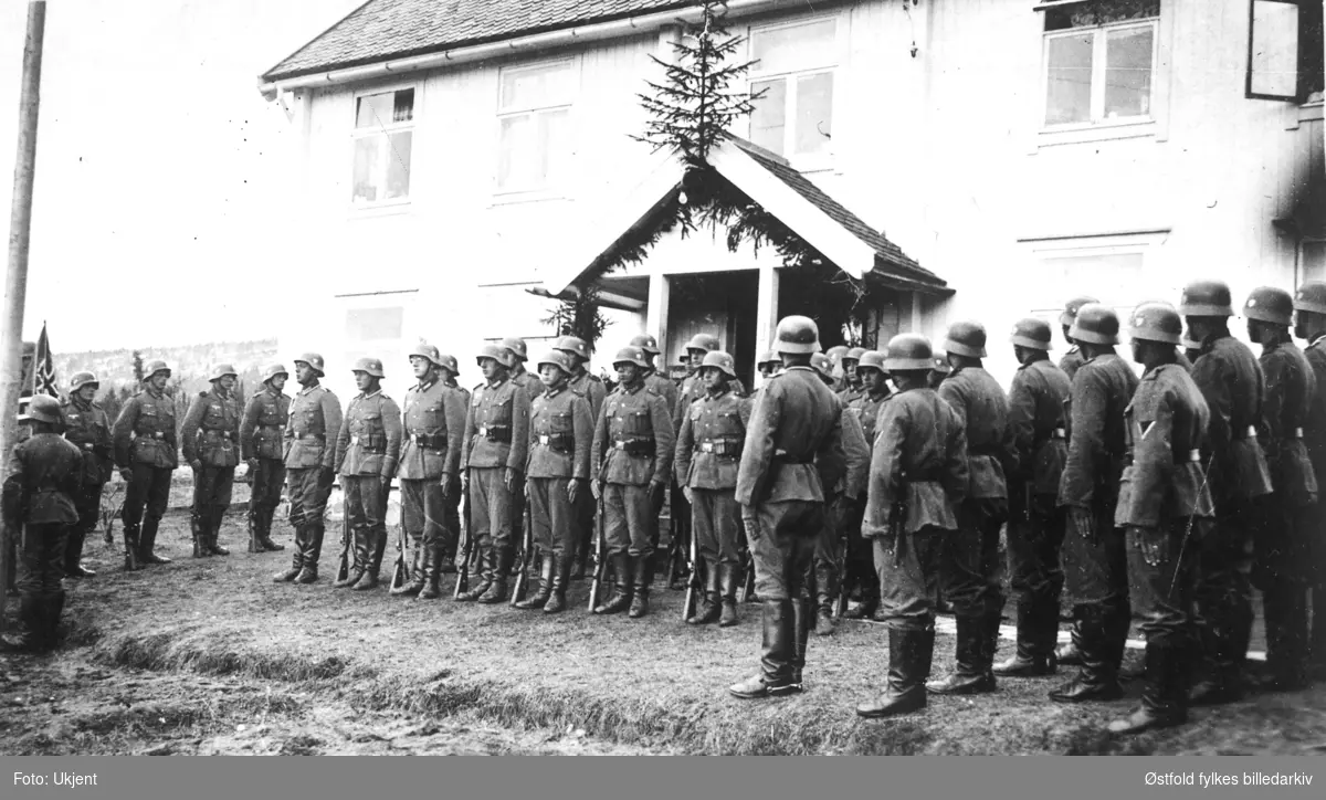 Tyske tropper i på Eggen gård, Ulsberg i april 1940. Tyske soldater oppstilt utenfor våningshuset. Grantre over inngangsparti og granbarportal (begravelse?).