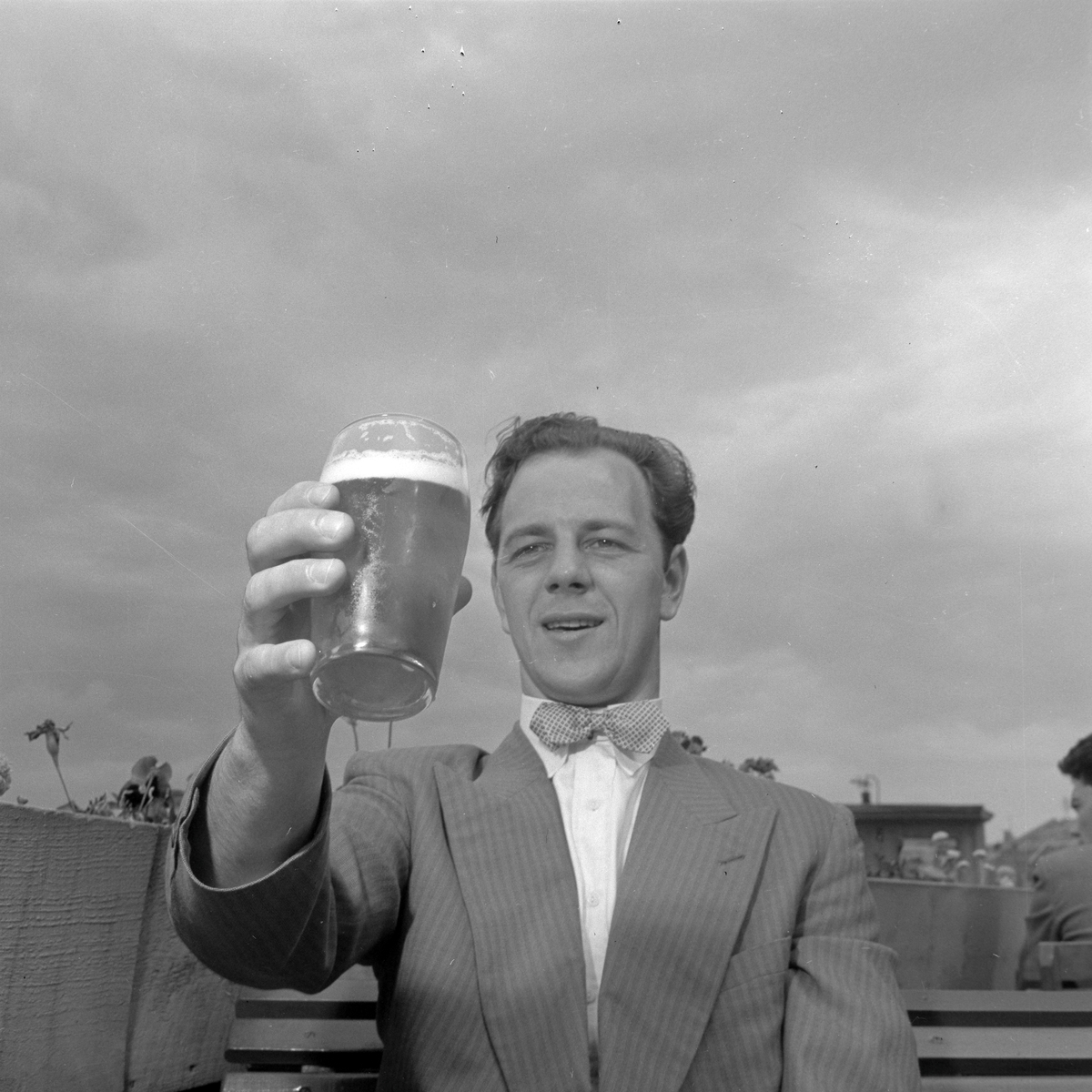 Mann nyter en øl på Skansen i sommervarmen