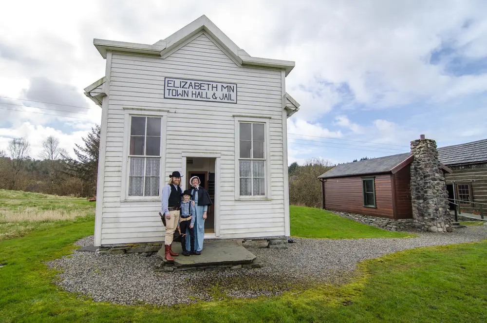 Par og barn i drakt utenfor Elizabeth town hall & jail