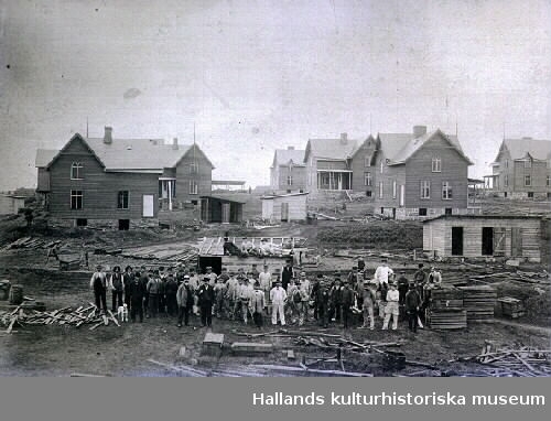 Egnahemsförening, på Östermalm, bildad av anställda vid järnvägen Varberg-Borås. På bilden arbetare och arbetsledare, eventuellt blivande ägare framför en del av villorna. Från 1905-1906. Se VMA8828 för fler uppgifter.
