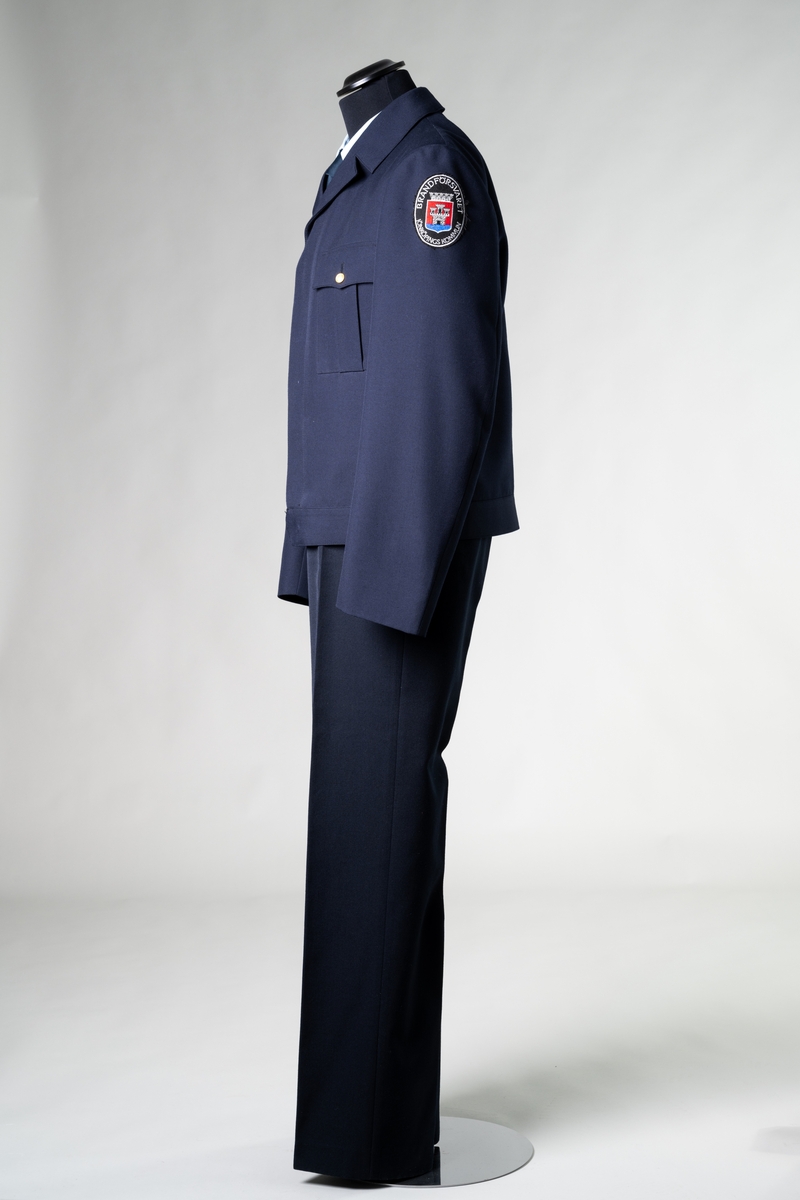 Uniform, stationsuniform, modell sommar, för personal vid Brandförsvaret, Jönköpings kommun. Uniformen består av jacka, byxa, två skjortor, slips och skärmmössa.

Samhör: 56718:1-6.

Objektsbeskrivningar i underposterna.

Se vidare Historik.
