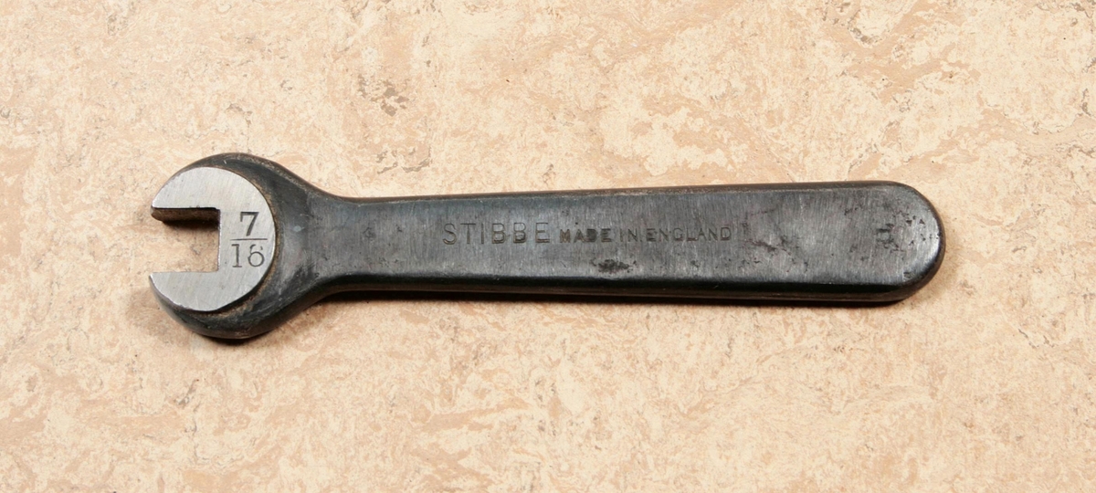 Fast nyckel av stål. Enkel U-nyckel. Märkt: 7 / 16, STIBBE MADE IN ENGLAND. Proveniens Fritz Sjöbloms Trikåfabrik, Borås.