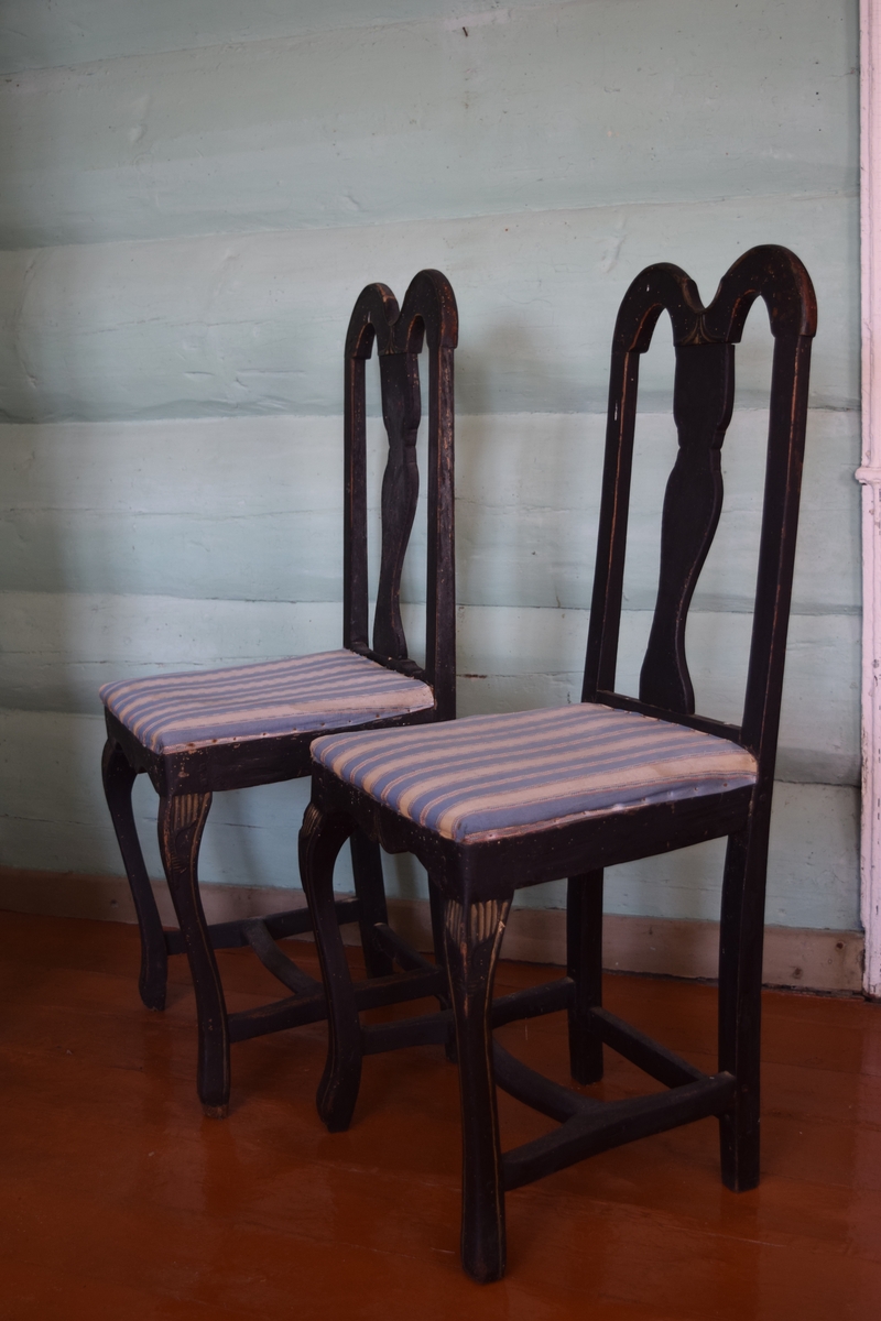To sortmalte stoler i bonderokokko uten armer. Trekket er i hjemmevevde farger.