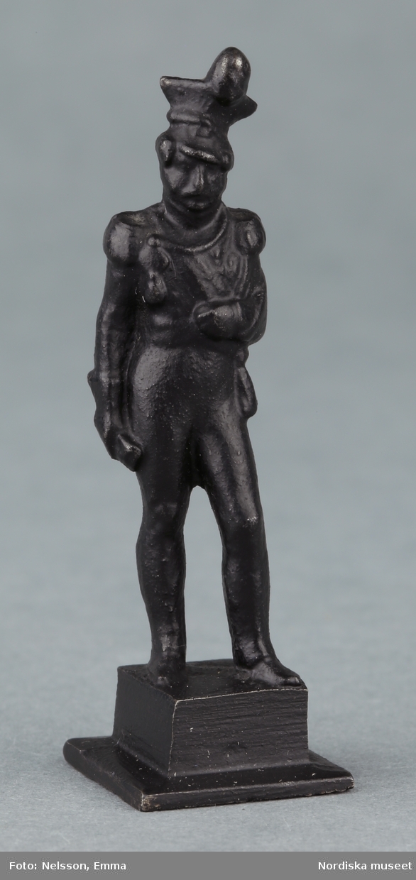 Inventering Sesam 1996-1999:
H  5  cm
Statyett, prydnadsföremål, av järn, svart, föreställande stående militär på kvadratisk sockel.
Birgitta Martinius 1997