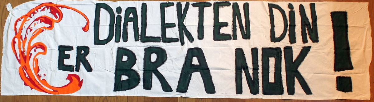 Banner frå arkivet til Norsk Målungdom. På banneret står teksten: "Dialekten din er bra nok!". Det er truleg at banneret har vore i bruk under ein dialektaksjon for Norsk Målungdom.