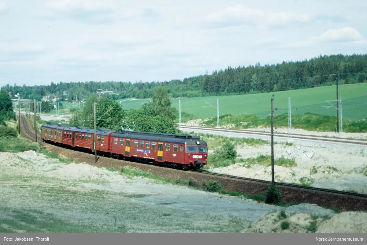 Lokaltog til Moss, tog 2745, med elektrisk motorvognsett type 69 ved Høyåssvingen ca. km 34 mellom Ås og Vestby stasjoner på Østfoldbanen. I bakgrunnen nytt dobbeltspor under bygging