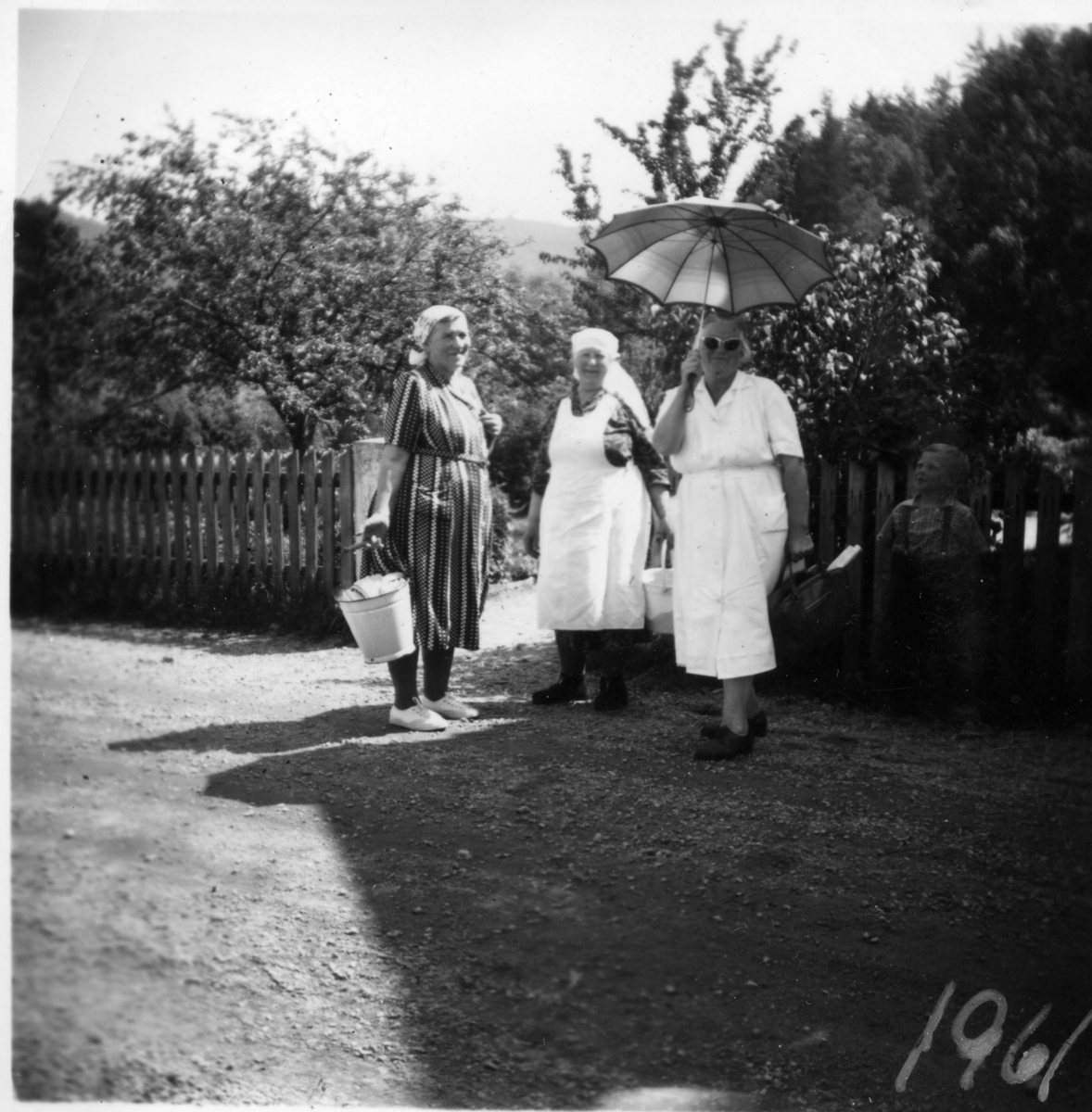 Tre kvinner fra Røyknes på vei til å vaske klær. Røyknes var en stasjonsbygd langs Setesdalsbanen. 