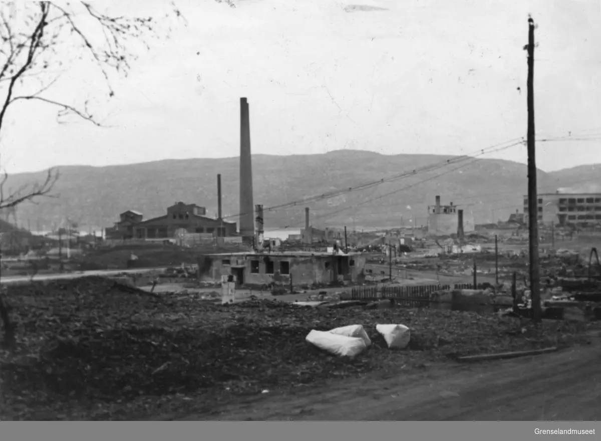 Kirkenes etter bombingen 4/7-1944. malmklangs kinolokale i forgrunnen, dampsentralen med pipene i bakgrunnen.