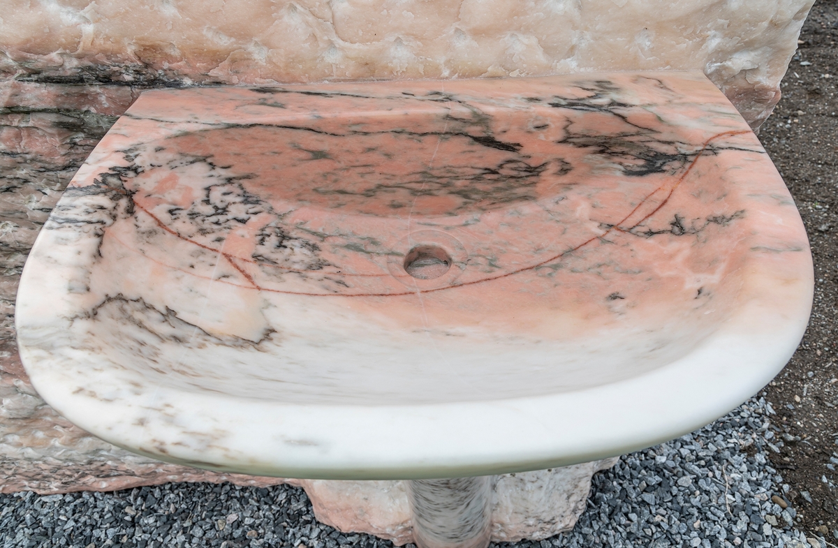 "The Waste" er hugget i rosa marmor, en bergart som var populær i europeiske baderom gjennom 1980-årene. Teknikken kunstnerne har brukt, kalles non finito og betyr «uferdig». Vi ser underkroppen til et menneske som stikker ut ved siden av en vask; resten av kroppen er skjult inne i steinen. Skulpturen er tvetydig i motiv og utførelse.

Verket er plassert mellom Ås kirke og Veterinærbygningen og gir assosiasjoner til liv og dødelighet samt menneskets forfengelighet og avfall. Selv om kunstnerne jobber i et figurativt formspråk og med tradisjonelle teknikker og materialer, kan skulpturene oppfattes som både fremmede og «upassende» i den forstand at noe ikke helt stemmer.

Daniel Dewar og Grégory Gicquel er en engelsk-fransk duo som har jobbet sammen i flere år.