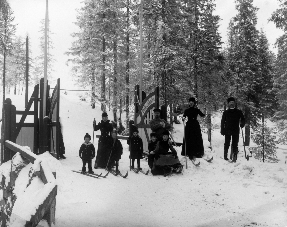 Folk på ski og kjelker i skogen ved Voksenkollen.