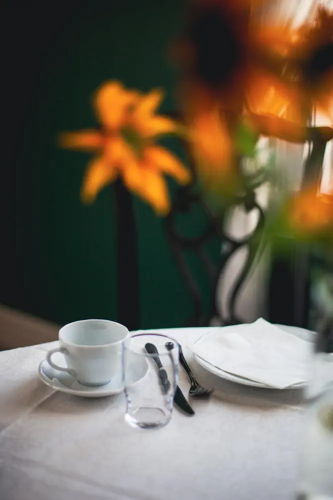 Foto av oppdekking med kaffekopp, glass, asjett og bestikk.