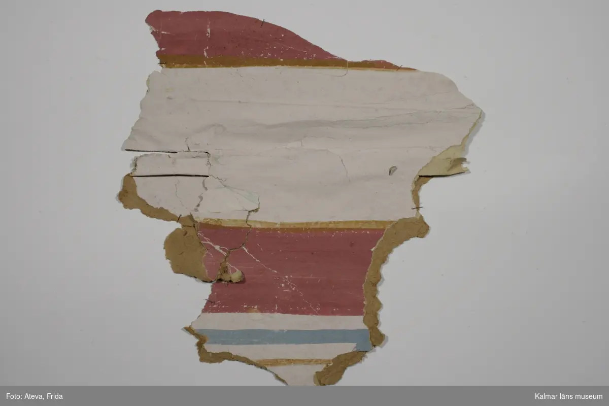 KLM 43769:5. Tapet av papper. Målad tapet med olika fält i rosa, brunt och blått.