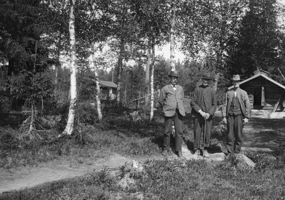 Tre fløterveteranter, fotografert framfor koia ved Grundsetfossen i Elverum våren 1920. Fra venstre ser vi Martin Andersen Bolstad (1871-1952), Per Embetsen Fossum (1846-1925) og Peder A. Kjeljebakken (1847-1926).