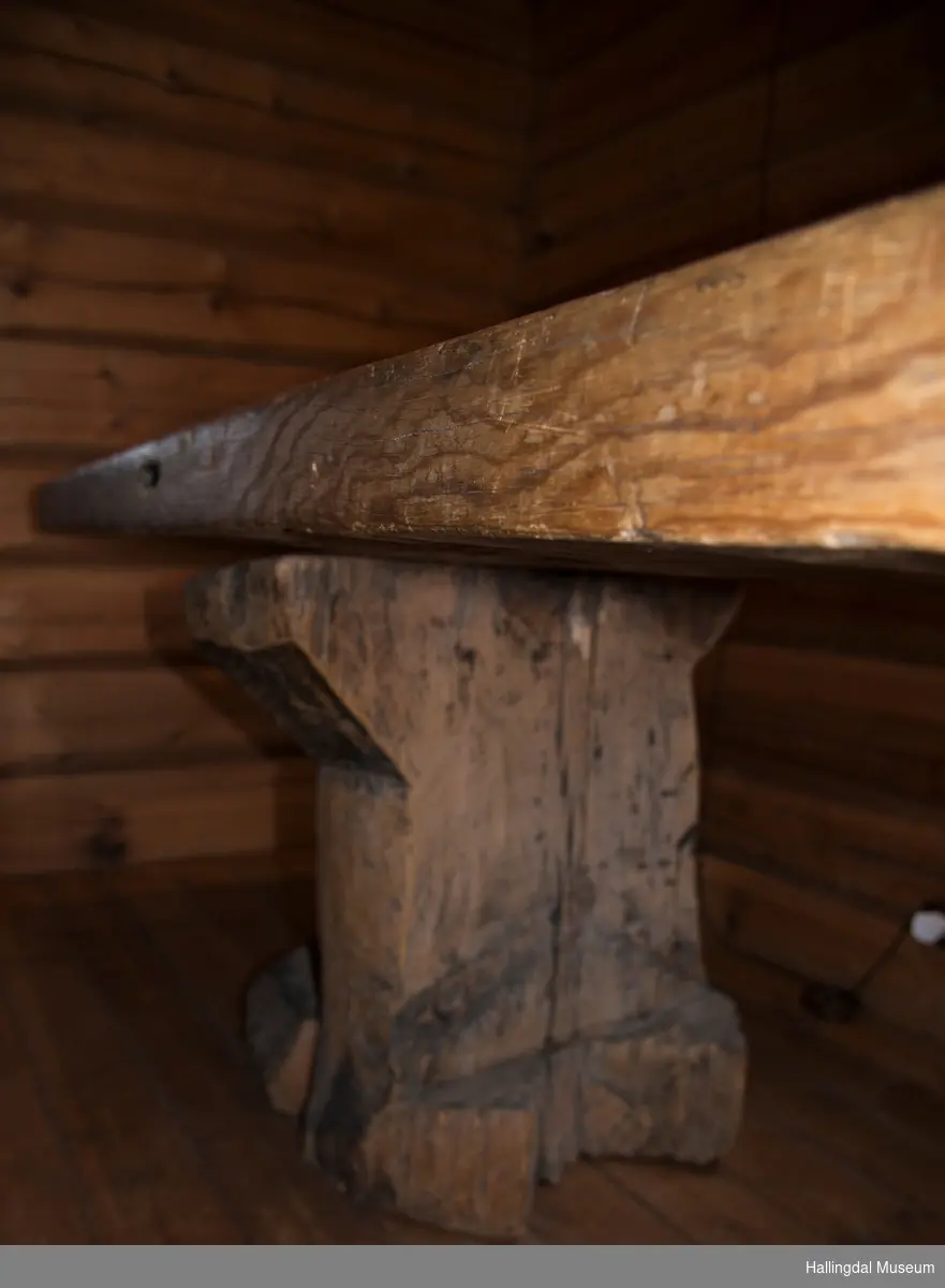 Lanbord som er lagd av en stor planke.  Det hviler på 2 store stabber. I ene bordeneden er det slått inn 4 hvite melketenner og 2 grå steiner eller melketenner (usikker).