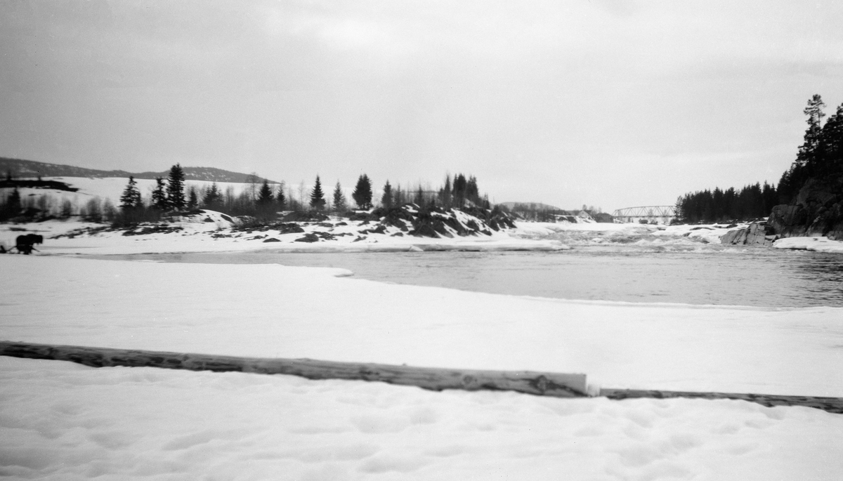 Etter isskytningen i Fossvika ovenfor Braskereidfoss, Våler, Hedmark. Vann, snø og is i Glomma. Bru i bakgrunnen.