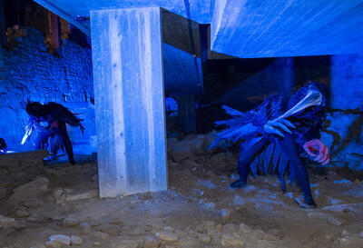 To svarte ravner danser i blått lys i ruinene etter bispegården, som onde varsler.