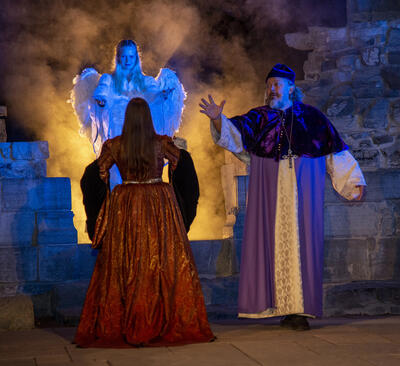 Biskop Mogens tar farvel med en død jomfru Karine som ledes inn i lyset av en engel.