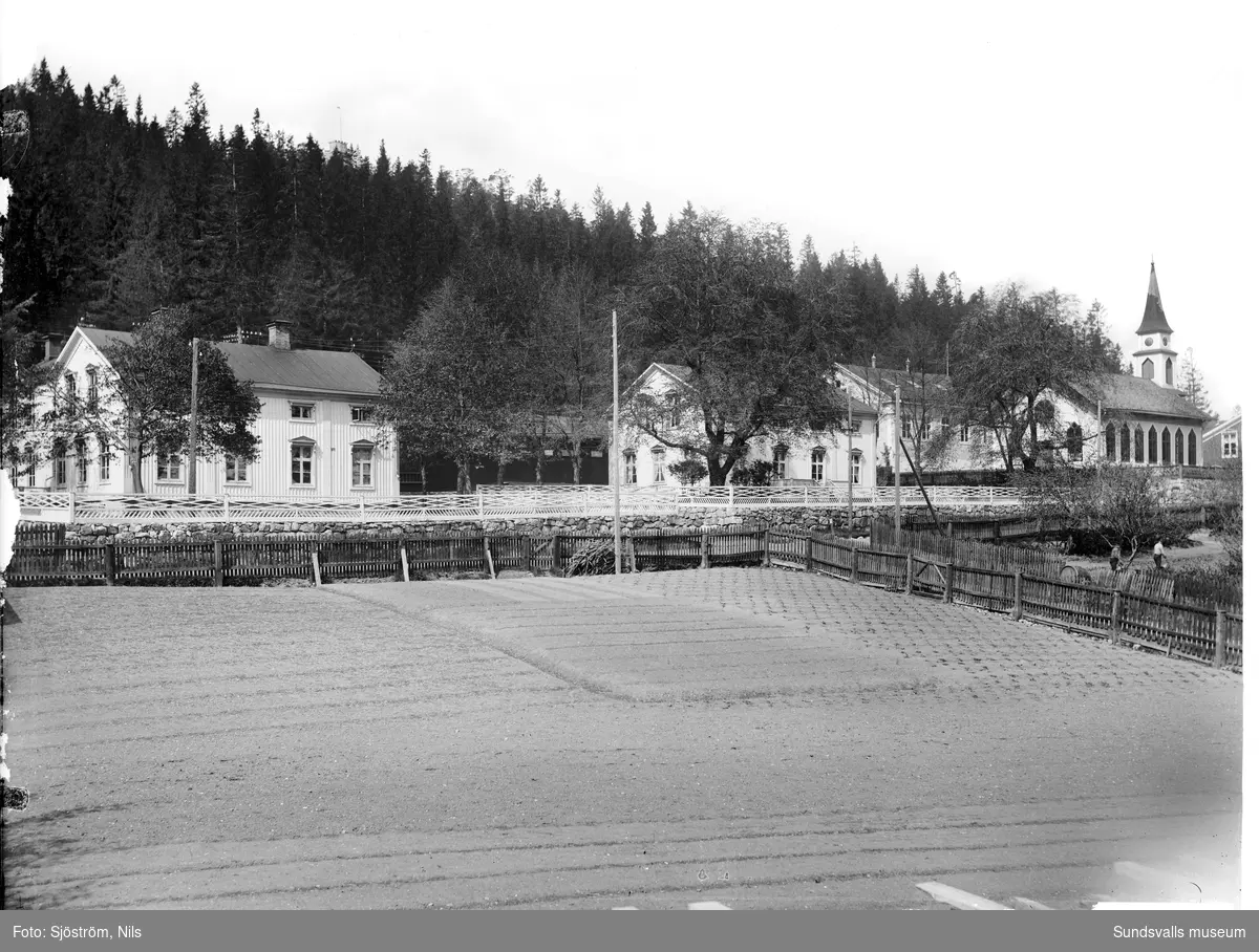 Gammal vy med Svartviks trädgård i förgrunden, sågverkskontoret, prästgården, kyrkan och bredvid kyrkan Svartviks första skola. Ovanför trädtopparna skymtar även kastellet.