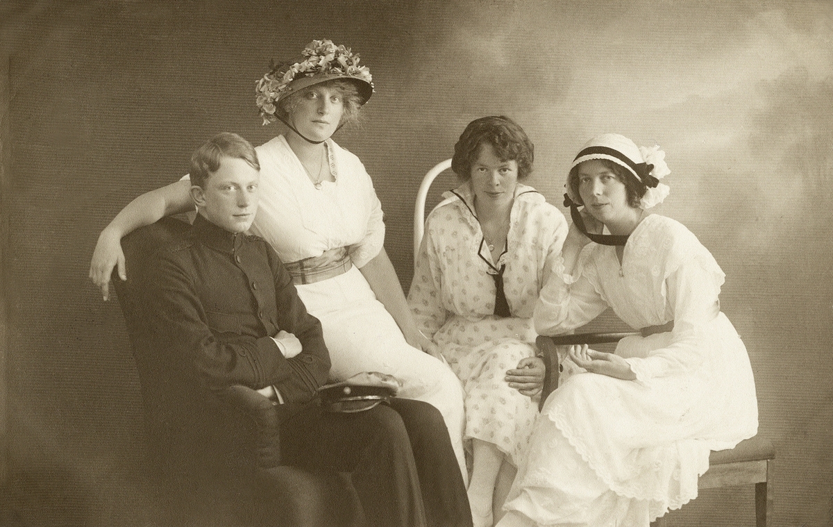 Tre unga kvinnor och en ung man poserar för fotografen i en ateljé, 1915.