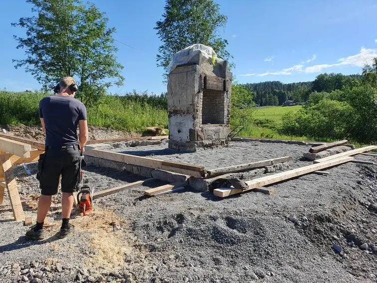 Esse på plass på ny tomt. Fint sommervær. Odd Martin Nilsson står til venstre i bildet med øreklokker på. Fint sommervær.