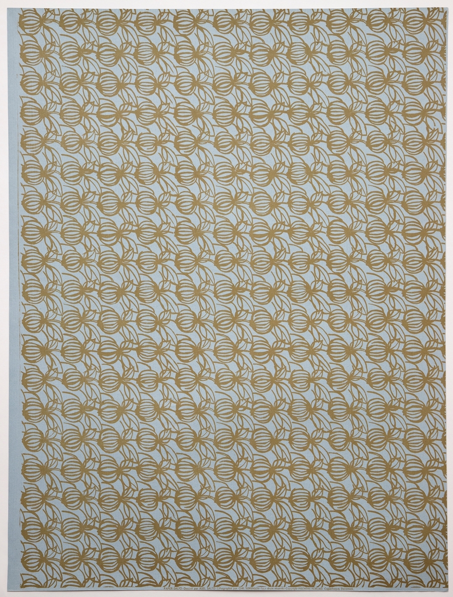 Rektangulært dekorativt papir med mønsteret "Granatæbler". Forsiden er dekorert med et repeterende mønster av stiliserte fruktformer - omgitt av olivengrønne konturlinjer - på lyseblå bunn. Mønsteret skal forestille stiliserte granatepler.