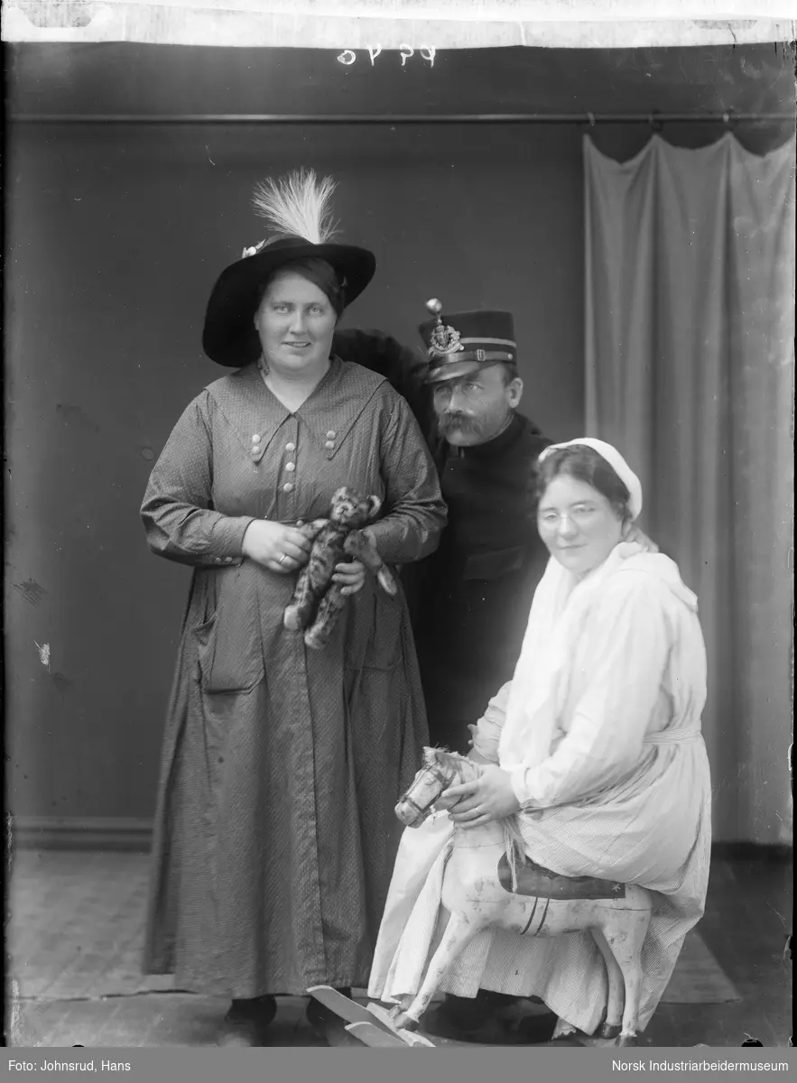 Portrett av tre personer. En mann og en kvinne som holder en bamse stående bak, og en kvinne foran sittende på en gyngehest