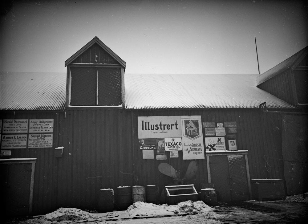 Alstahaug, Sandnessjøen. En lagerbygning med ulike reklameskilt på veggen, i Sandnessjøen.