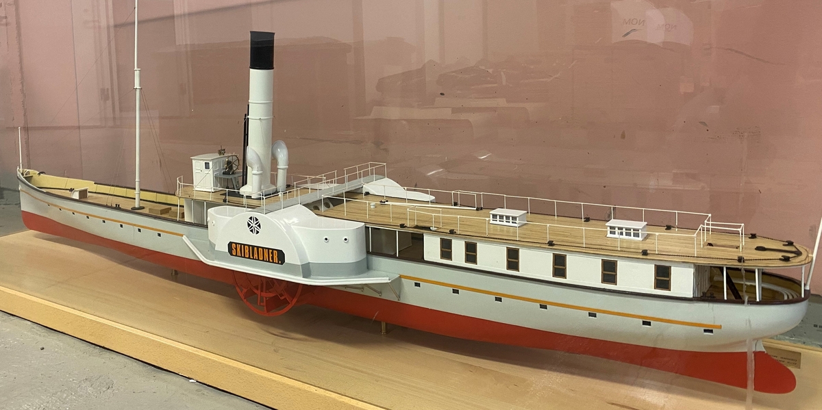 Modell av skipet D/S Skibladner i skala 1:30. Modellen står montert på en tresokkel med glassmonter på alle sider.