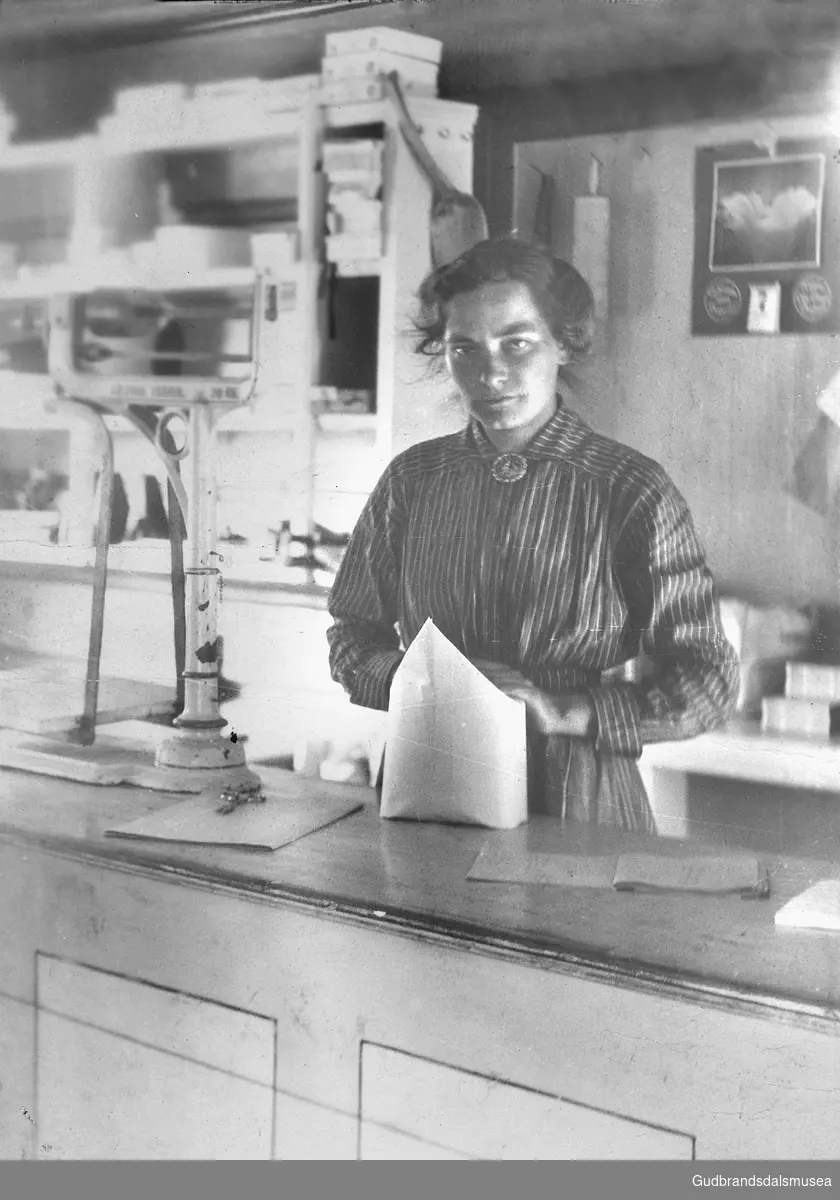 Ragnhild Risheim (f. 1892 g. Tjønneland) bak disken på Bøverdalen koop. handelslag før 1917