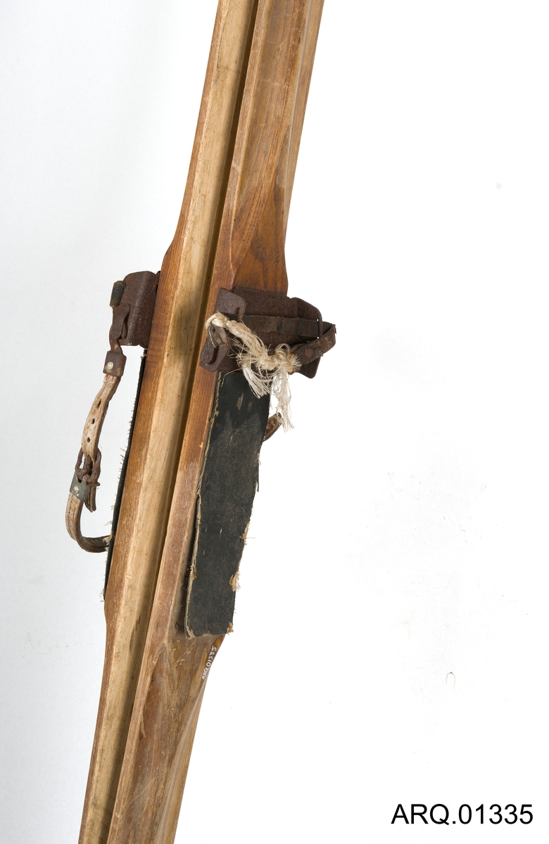 Treski, ett par med påskrudde feller med formpass til støvlen og med festereim i skinn både rundt ankel og over rist. Fremst på skituppen er det et varemerke, kan se ut som det står noe med "Hardanger".