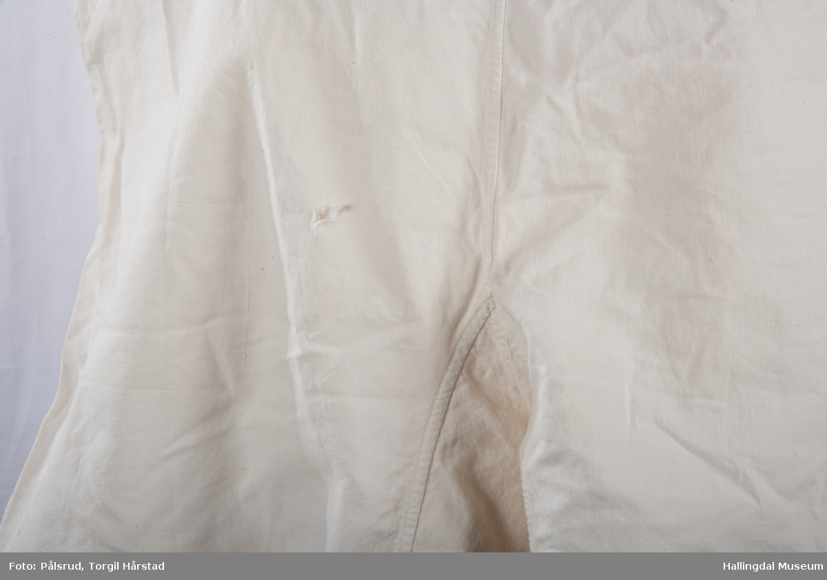 Hvit underbukse i bomull med hvite heklet blonder. Hjemmesydd. Har kiler i skritt og to splitter i livet.