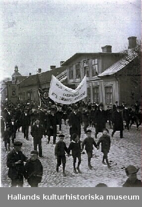Demonstration 1:a maj. "Årlig... Lagstadgad åtta timmars arbetsdag". Fototid (osäker) 1910-tal. Möjligen Torggatan Varberg.