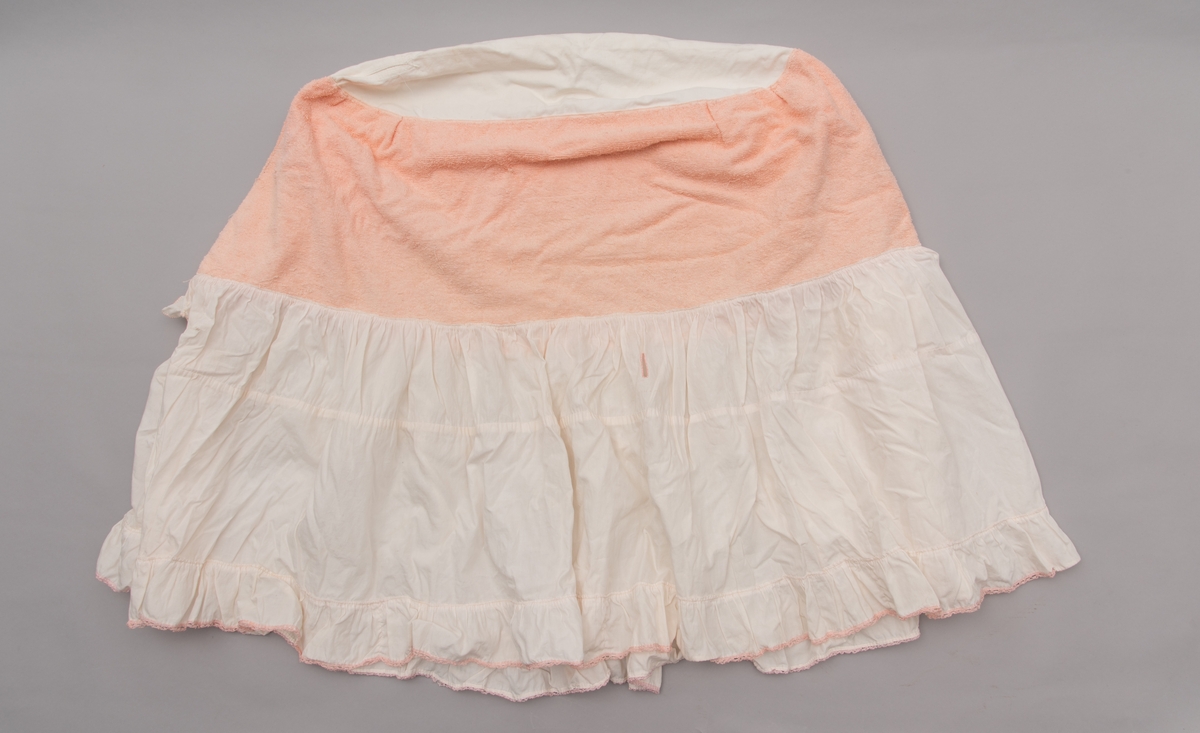 Hvitt formsydd laken med kapper til babykurv. Rosa frotté-innlegg og rosa blonde nederst på kappen.