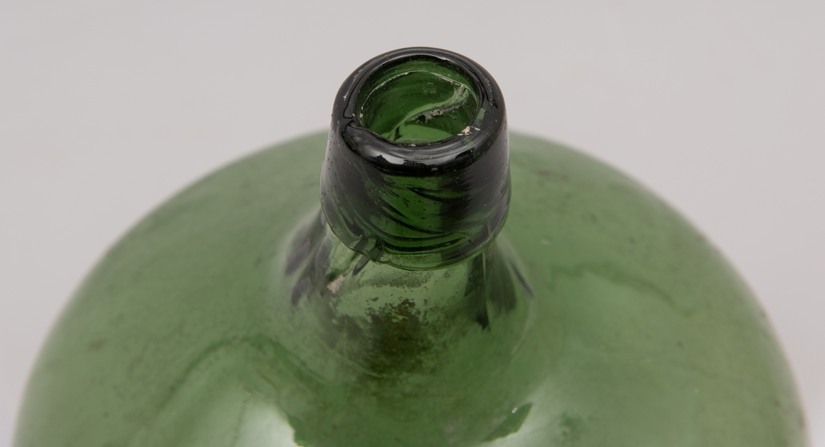 Grønn ballongformet flaske av glass.