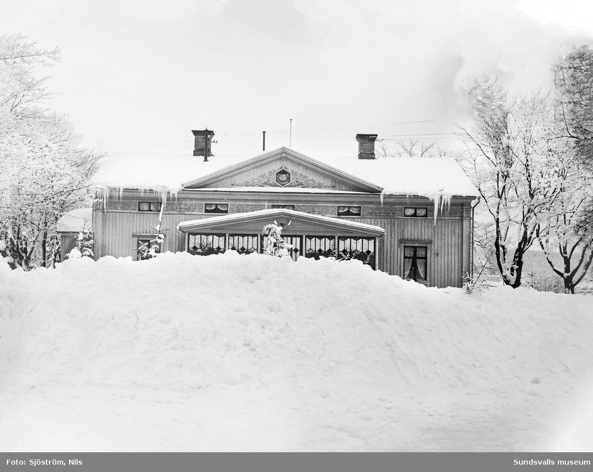 Svartviks herrgård med höga snödrivor framför.