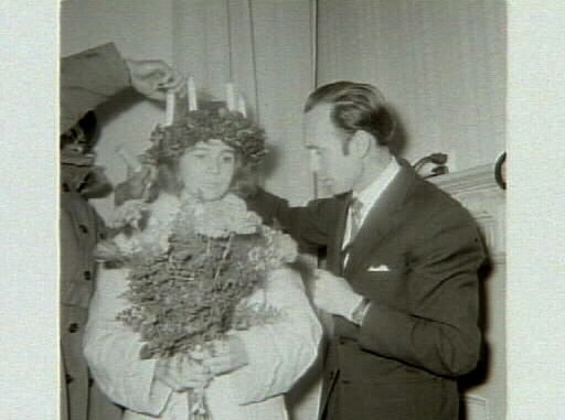 Kröning av 1961 års Lucia, Marianne Lindblom, erhåller Luciasmycket av museichefen Bengt-Arne Person. Artikel i samband med bilderna publicerad i Varbergs Tidning 1961-12-15.