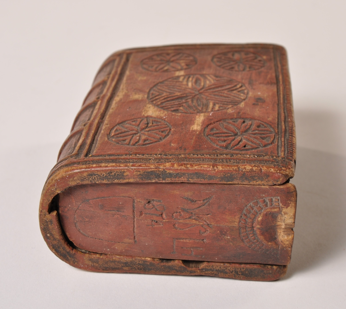Eske formet som en bok. Skyvelokk i begge ender. Utskjært dekor, datert 1814