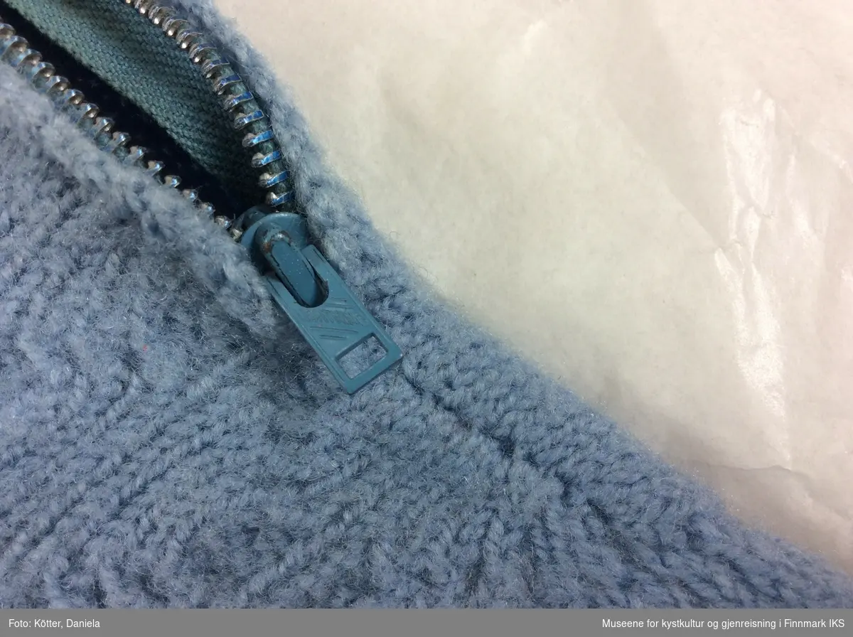 Bare genseren tilsvarer ca. størrelse 6 år. Den er stikket av blå ull. Det er satt inn en glidelås på venstre skulder. For- og bakside av bollen er strikket separat og satt sammen. Forsida har et mønster, mens baksida og armene er glattstrikket.